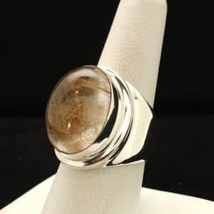 "A sterling silver ring featuring a high-dome rutilated quartz stone with a thick shank, size 9, part of the Ethnographic line by Turquoise Deluxe."