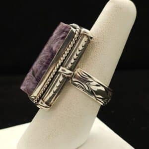 "A sterling silver ring featuring a charoite rectangle stone with a fancy bezel and carved band, size 8, part of the Style Ethnographic line by Turquoise Deluxe."