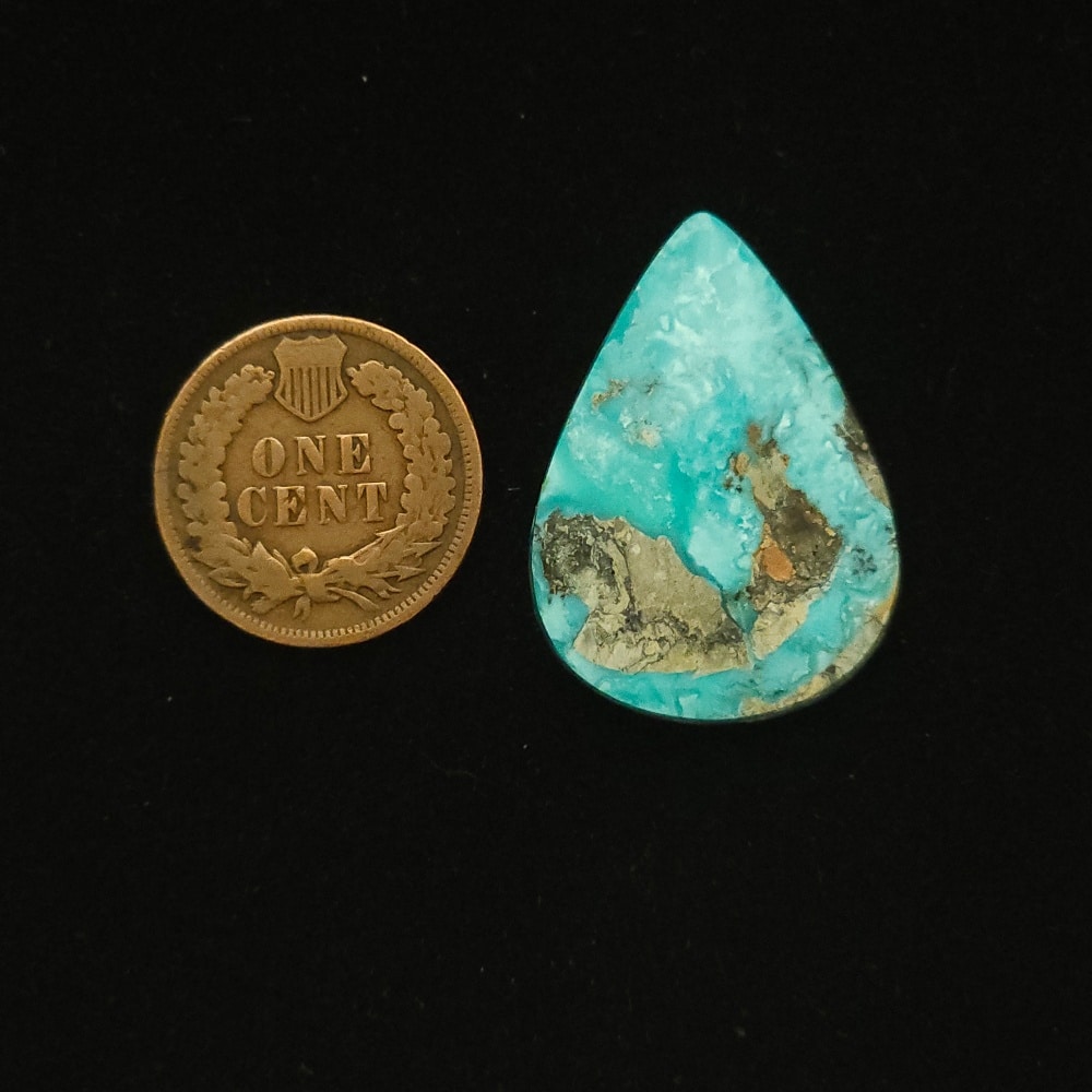 Vintage Godber-Burnham turquoise cabochon, 25.00 carats, teardrop-shaped, with ocean surge blue hues and black and golden matrix, hand-cut from 1970s Nevada rough.