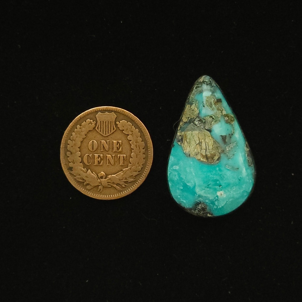 Teardrop-shaped Godber-Burnham turquoise cabochon in ocean surge blue with black and grey chert matrix, 27.40 carats